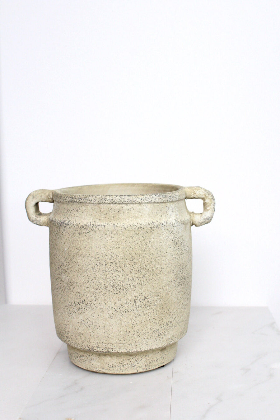a large white pot sitting on top of a white counter