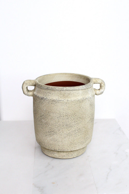 a white pot with a handle on a table