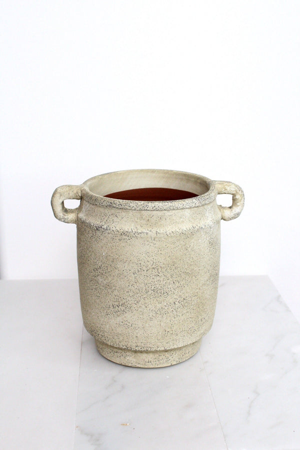 a white pot with a handle on a table