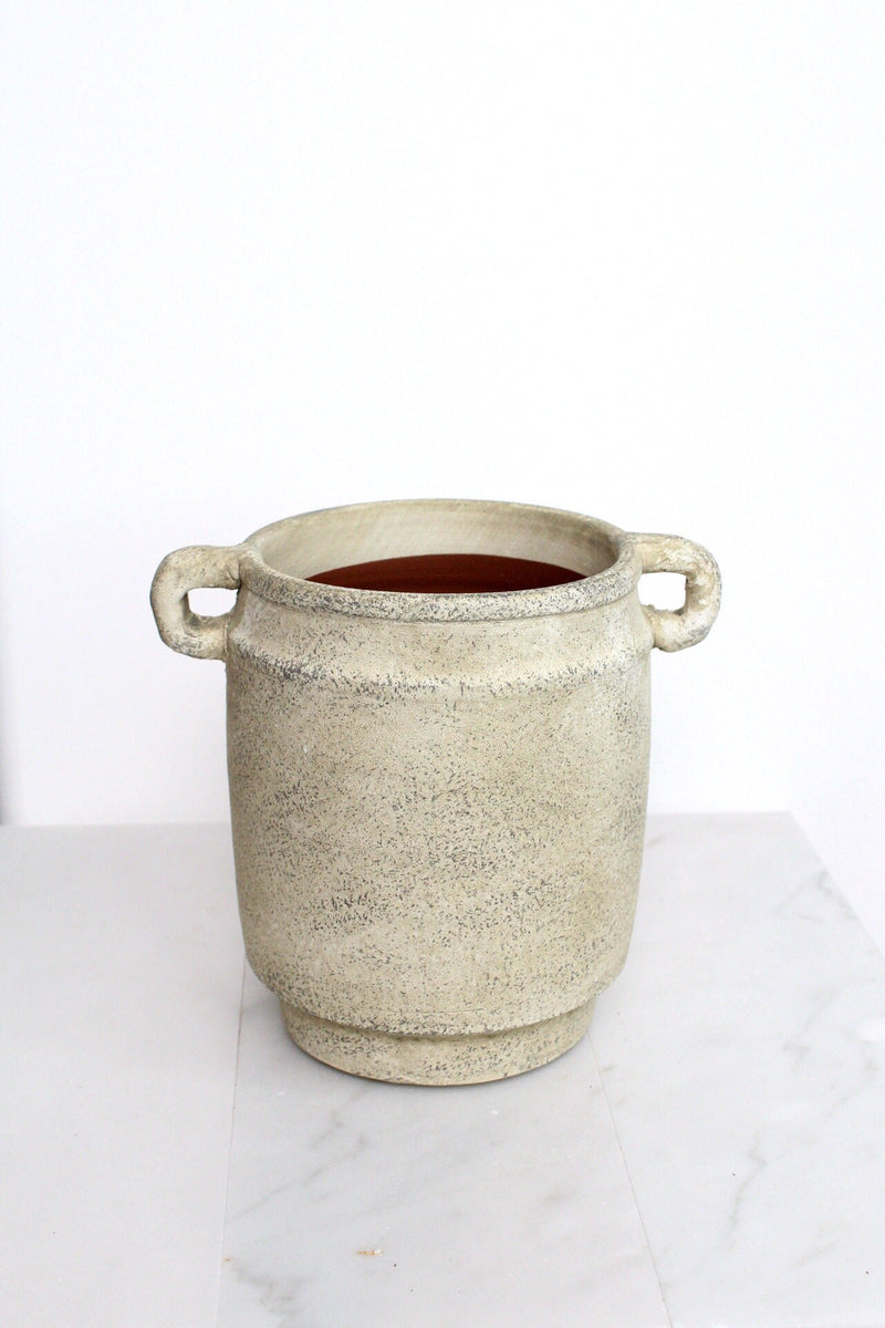 a white pot with a handle on a table